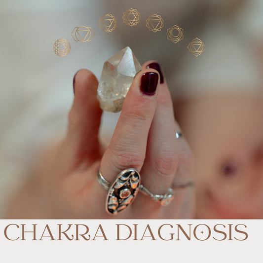 Chakra Diagnosis, woman is holding a crystal in her hand, rings on her fingers. Gold Chakra symbols arch above the crystal.